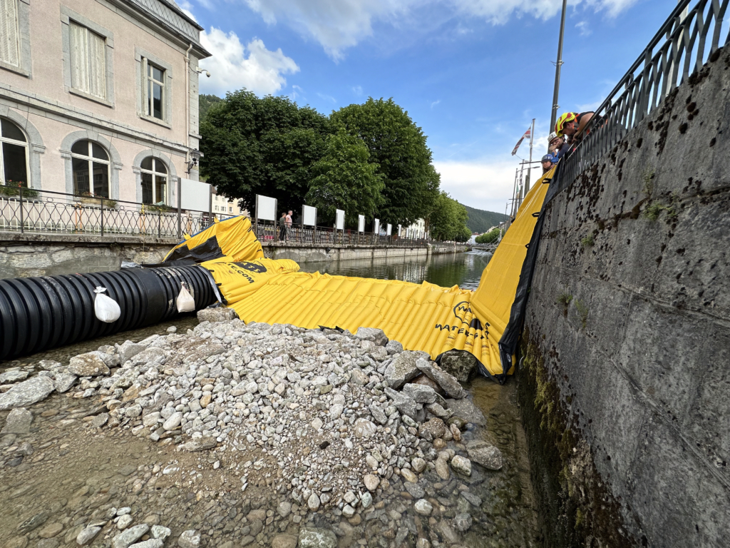 Batardeau souple Water-Gate appuyé verticalement contre un mur de rive avec canalisation DN1200 de dérivation